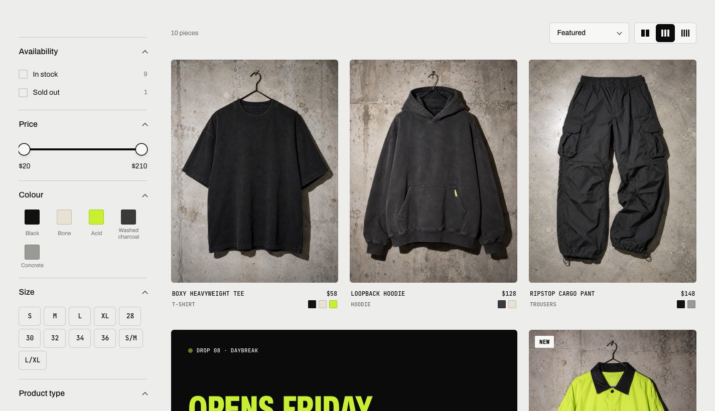 Graphite collection page with size filters and garments on hangers against concrete.